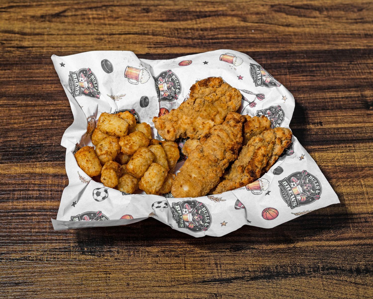 Four crispy chicken tenders served with tater tots in a basket