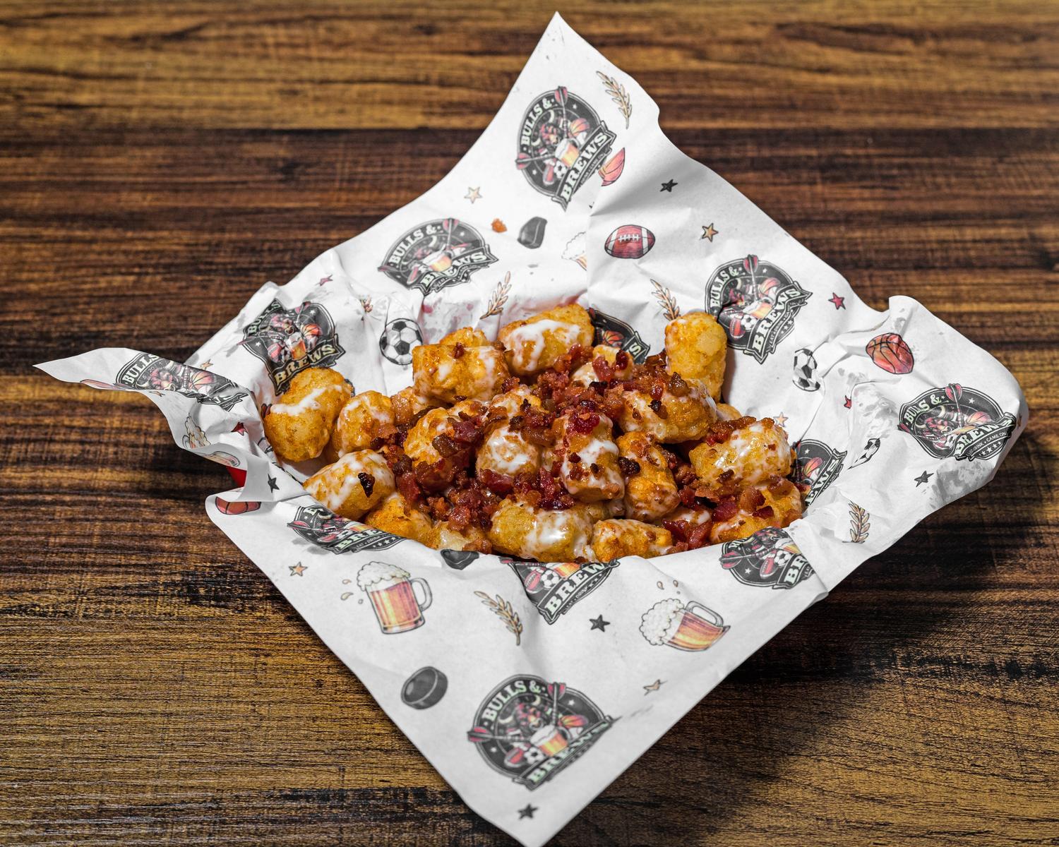 Loaded tater tots topped with cheese sauce and crumbled bacon